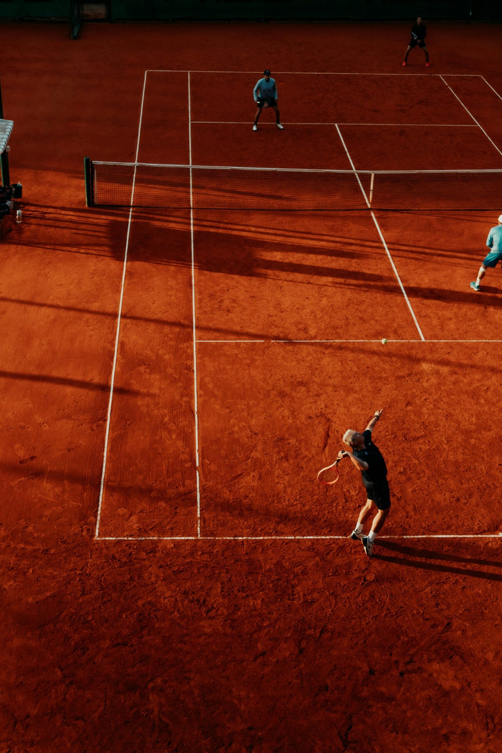 Friends playing doubles tennis together